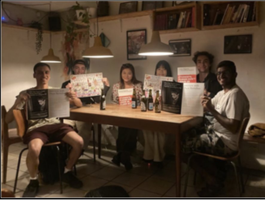 Volunteers from DMFIS around a table holding pages from the magazine